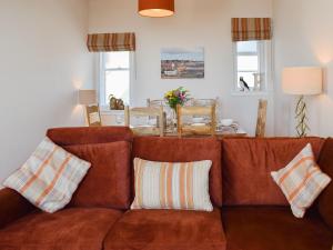 アンストラザーにあるHarbourside Apartmentのリビングルーム(枕付きのブラウンソファ付)