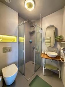 a bathroom with a glass shower and a sink at Ruby Hostel - Lux Group Dorm Rooms in Kutaisi