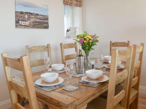 アンストラザーにあるHarbourside Apartmentのダイニングルームテーブル(椅子付)、木製テーブル(花付)