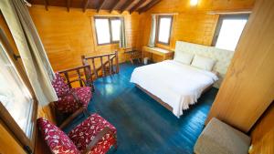 ein Schlafzimmer mit einem Bett und Stühlen in einem Zimmer in der Unterkunft Welt Bungalows Belenbaşı in Hurmaköy