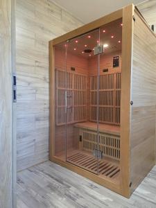 a wooden sauna with a glass door in a room at Dům v Beskydech – Trojanovice in Trojanovice