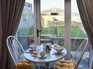 ein Tisch und Stühle vor einem Fenster in der Unterkunft Primrose in Scruton + 16 Fotos
