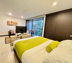 a large bedroom with a large bed and a television at Apartasuite cercana al aeropuerto internacional MED in San Antonio de Pereira