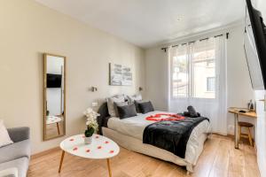 a bedroom with a bed and a couch and a table at Le Bourget - Envolée Romantique in Narbonne
