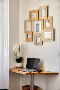 a desk with a laptop on a table with pictures on the wall at Le Bourget - Envolée Romantique in Narbonne