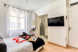 a bedroom with a bed and a flat screen tv at Le Bourget - Envolée Romantique in Narbonne +18 photos