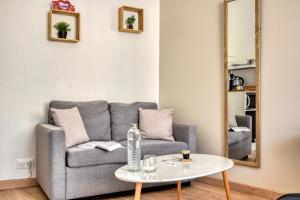 a living room with a couch and a table at Le Bourget - Envolée Romantique in Narbonne