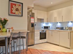 a kitchen with white cabinets and a counter top at The Orangery in Bideford