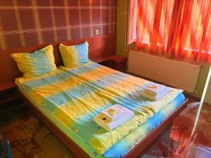 a bed with colorful sheets and towels on it at Къща за гости Орешака in Oreshak