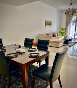 a living room with a dining room table and chairs at Al Dana Palma Villa - Luxury 4-bedroom villa with Heated Pool & Mountain Sea View in Fujairah