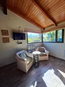 a living room with two couches and a tv at Cabañas Casa Verde in Potrerillos