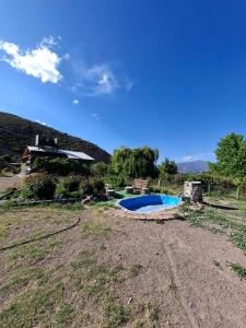 a yard with a swimming pool in front of a house at Cabañas Casa Verde in Potrerillos