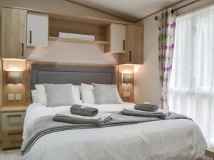 a bedroom with a large bed with towels on it at Graylings Rest - Uk35759 in Brigham