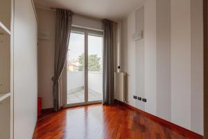 an empty living room with a large glass door at myhomEgallarate in Gallarate