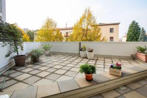 a patio with potted plants on a white fence at myhomEgallarate in Gallarate