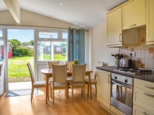 eine Küche und ein Esszimmer mit Tisch und Stühlen in der Unterkunft Boobys Bay - Uk47554 in Saint Merryn