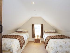 Zimmer im Dachgeschoss mit 2 Betten und einem Fenster in der Unterkunft Stable Cottage - Hw7452 in Whitford
