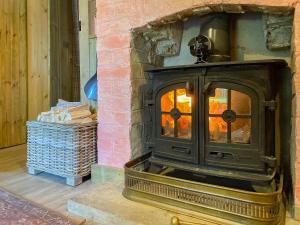 ハンティンドンにあるThe Potting Shedのレンガの壁のある部屋にある古い薪ストーブ
