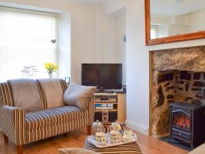 a living room with a couch and a fireplace at Salty Cottage in Newlyn