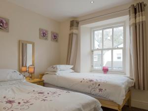 a bedroom with two beds and a window at Esthwaite in Windermere