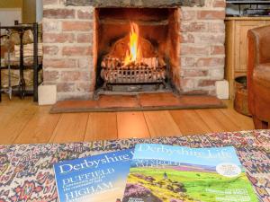 a living room with a fireplace with a book at The Smithy - E5445 in Brassington