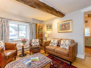 a living room with a couch and chairs and a table at The Smithy - E5445 in Brassington