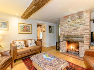 a living room with a couch and a fireplace at The Smithy - E5445 in Brassington