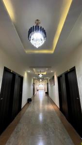 a hallway with a chandelier and a long corridor at Hotel Yashoda Palace in Kota
