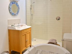 a bathroom with a tub and a sink and a bath tub at The Barn in Greystoke
