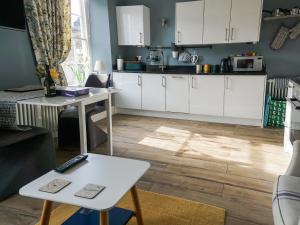 a kitchen with white cabinets and a table at Bookkeepers Place in Bakewell