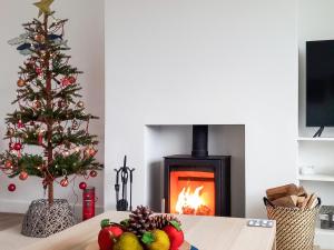 a living room with a christmas tree and a fireplace at Blue Horizon in Sidmouth