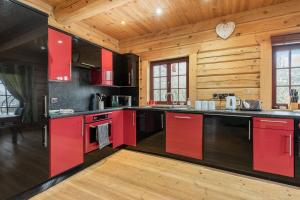 a kitchen with red cabinets and wooden walls at Ty Ceirios - Uk42100 in Carno +18 photos