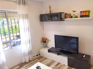a living room with a flat screen tv on a wall at Villa Mayki in Cacicedo