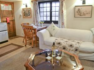 a living room with a white couch and a table at Byre Cottage - 29410 in Elmsted
