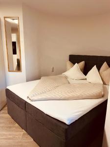 a large bed with white sheets and pillows on it at Haus Dominik in See