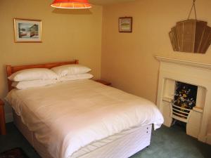 Un dormitorio con una cama y una chimenea. en High Birch Close, en Penruddock 7 fotos más