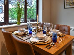 a wooden table with chairs and a candle on it at Havre De Calme in Halstead