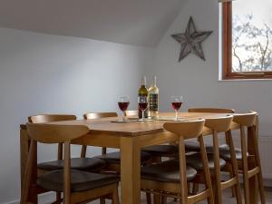 a wooden table with wine glasses and a star on the wall at Heron in Wroxham