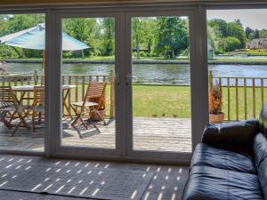 a screened in porch with a table and an umbrella at Watersedge - E1106 in Horning