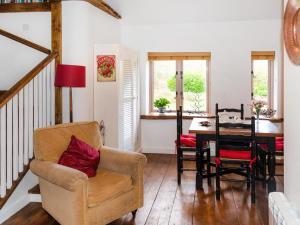 een woonkamer met een stoel en een tafel bij Brook Lodge in Bridford