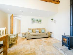 Una sala de estar con un sofá y una estufa de leña. en Pipistrelle - Uk30758, en Bream