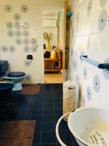 a bathroom with a toilet and a sink at Joli oasis au centre de l'île in Baie-Mahault +33 photos