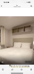 a bedroom with a bed with white sheets and pillows at Luxus Chalet Wattenmeerblick in Westerland