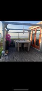a patio with a table and chairs on a deck at Luxus Chalet Wattenmeerblick in Westerland