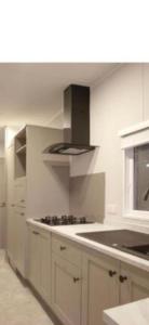 a kitchen with white cabinets and a stove top oven at Luxus Chalet Wattenmeerblick in Westerland +18 photos