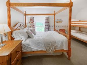 a bedroom with a wooden four poster bed at Hafod Fach - Ukc6956 in Moylgrove +15 photos