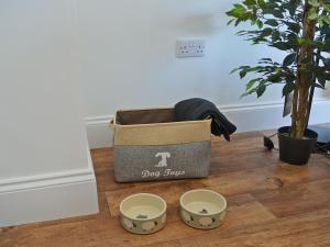 a dog box sitting on top of a wooden floor at Harry's Den in Chapel Saint Leonards +6 photos