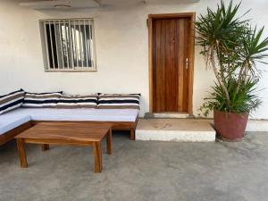 a room with a couch and a table and a door at Lou Fatm' Popenguine in Poponguine