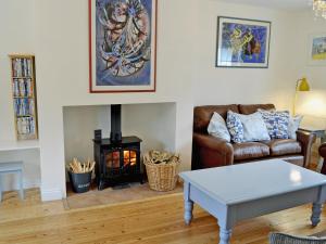 a living room with a couch and a fire place at Woodbrook Cottage in Bridport