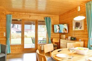 ein Esszimmer mit einem Tisch in einem Holzhaus in der Unterkunft Feriendorf Blauvogel Blauvogel 052 in Hasselfelde